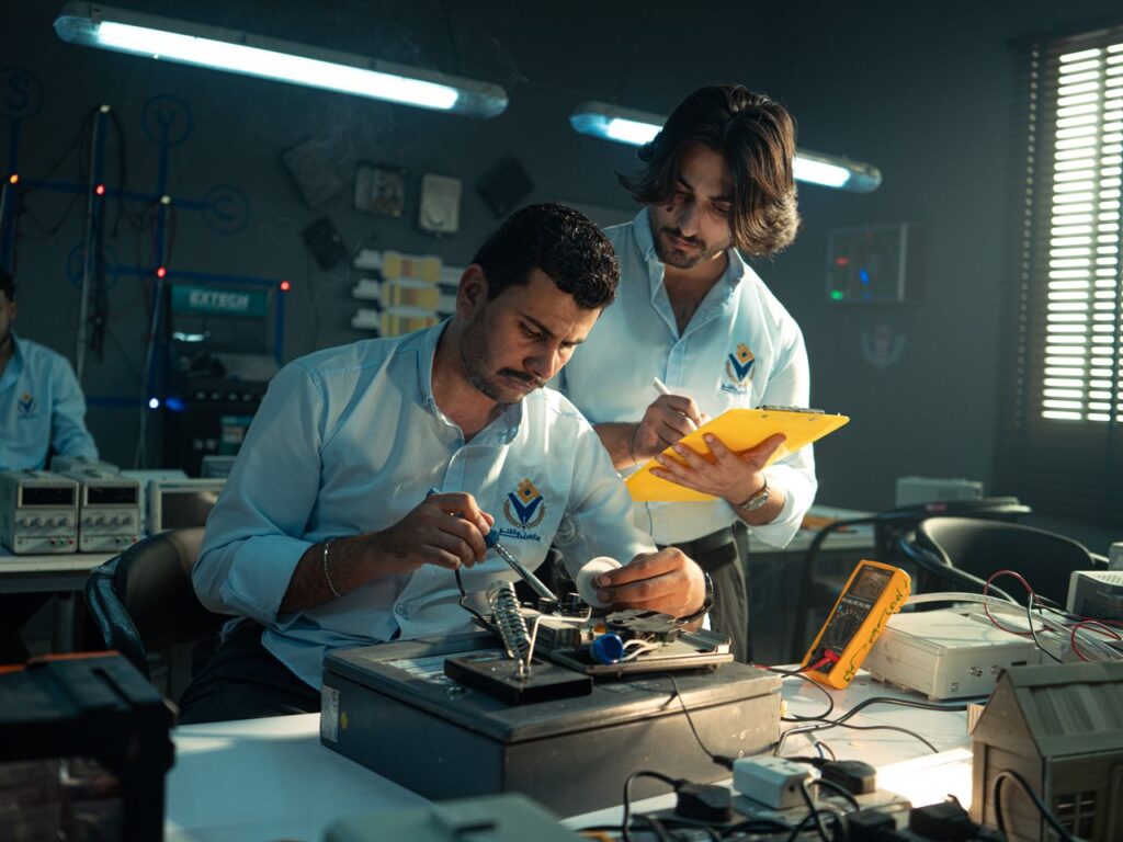 Focused technicians collaborate in an electronics lab, emphasizing teamwork and innovation.