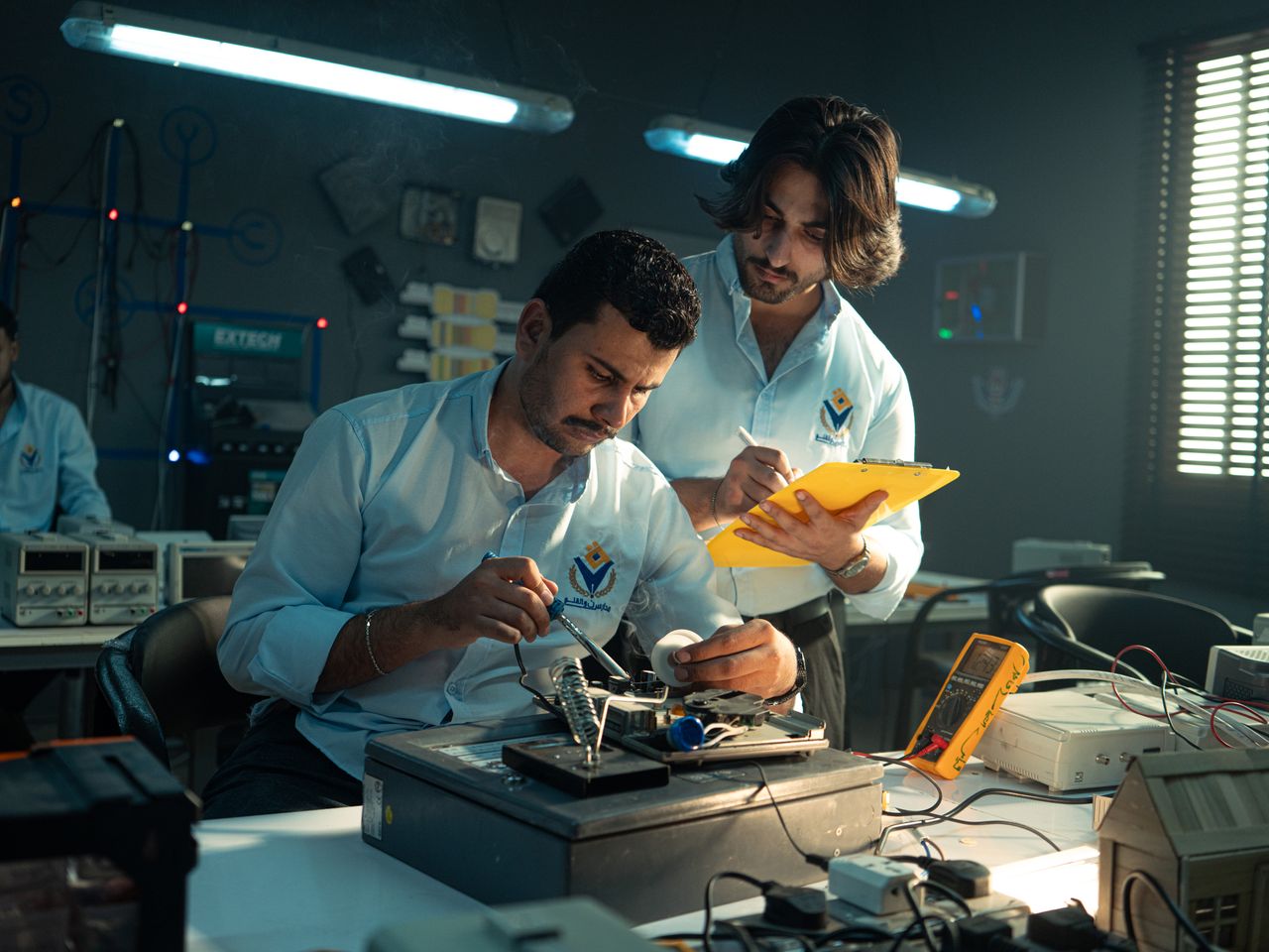 Mastering the First Impression: Your intriguing post title goes here Focused technicians collaborate in an electronics lab, emphasizing teamwork and innovation.